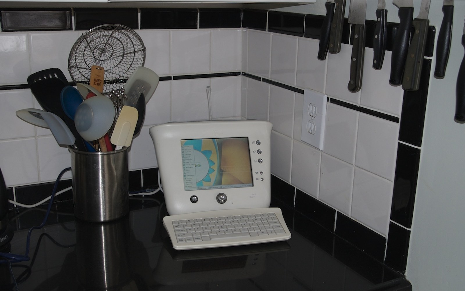 A 3Com Audrey internet appliance with keyboard sits on a kitchen counter beside utensils and knives