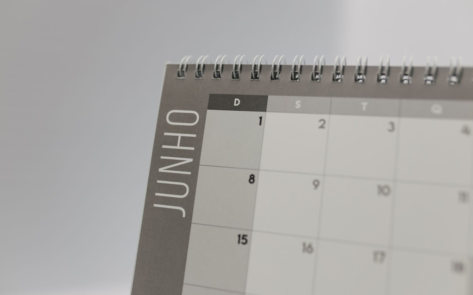 Close-up of a spiral-bound desk calendar page labeled "Junho" with numbered date grid