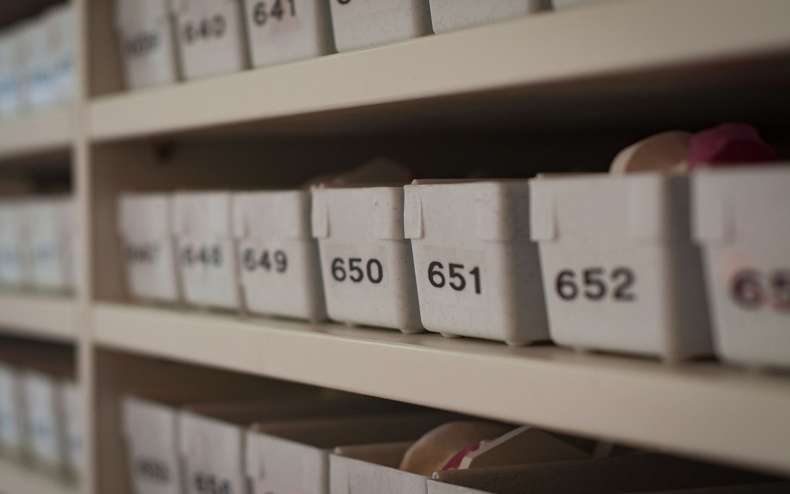 A shelf of identical dark plastic units, one raking light